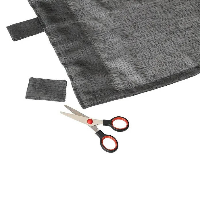 Elbersdrucke Schlaufenschal Effecto - 140 x 255 cm, 100 % Polyester, Anthrazit - Nahaufnahme von einer Schere mit Stoffresten, ideal für Schneiderarbeiten und DIY-Projekte.