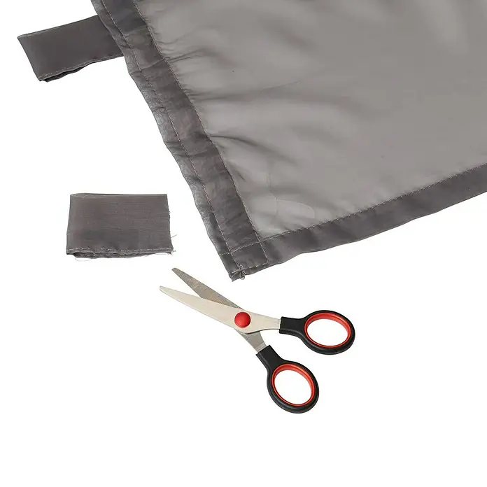 Elbersdrucke Schlaufenschal Feel Good - 140 x 255 cm, 100% Polyester, Grau - Nahaufnahme von Stoff, Schere und Stoffresten, die auf einem weißen Hintergrund zum Zuschneiden von Textilien bereitliegen.