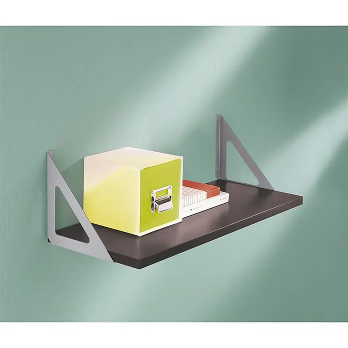 Dolle Soporte de pared para estantes Triangolo - Carga soportada: 50 kg, Acero, Gris - La imagen muestra una estantería de pared flotante de madera oscura con soportes triangulares gris plateados, con una caja decorativa colorida y un libro encima.