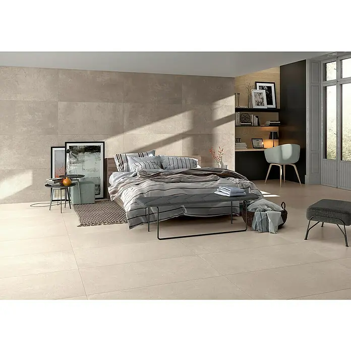 BHS Showroom Pavimento porcelánico Rodano - 120 x 60 cm, Taupe, Rectificado - Dormitorio con baldosas beige y una cama con ropa de cama a rayas. El diseño moderno de las baldosas crea un ambiente elegante en la habitación.