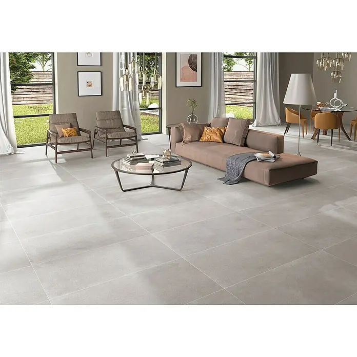 BHS Showroom Pavimento porcelánico Claire - 120 x 60 cm, Gris, Rectificado - Elegante sala de estar con baldosas de gran formato en color gris claro que crean una estética moderna y minimalista.