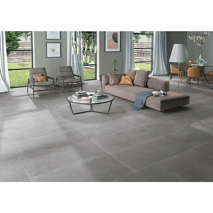 BHS Showroom Pavimento porcelánico Claire - 120 x 60 cm, Cemento, Rectificado - Elegante sala de estar con baldosas de suelo grises de gran formato, creando un ambiente moderno y elegante. Las baldosas son fáciles de mantener y duraderas.