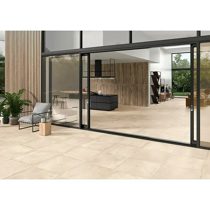 BHS Showroom Pavimento porcelánico Stoneage Soft - 60 x 60 cm, Arena, Espesor: 9,5 mm, Rectificado - Vista interior con baldosas de suelo beige, separadas del exterior por una puerta corredera de cristal. Suelo moderno para espacios habitables.