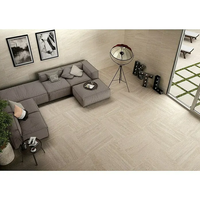 BHS Showroom Pavimento porcelánico Carleen - 75 x 37 cm, Marrón, Rectificado - Imagen de un salón moderno con suelo de baldosas de color claro, un sofá elegante y detalles decorativos, creando un ambiente relajado y acogedor.