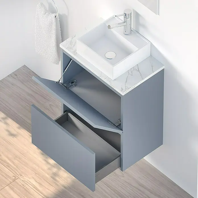 Artysan Conjunto de mueble de baño Picolo - Azul, Mate - El tocador gris moderno con tapa de mármol cuenta con un cajón abierto y puerta de armario.