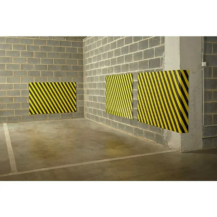 Mottez Schaumstoffmatte - L x B: 150 x 100 cm, Stärke: 1 cm - Drei Warnschutzpolster mit gelb-schwarzen Streifen sind an den Wänden eines Parkhauses befestigt, um vor Beschädigungen zu schützen.