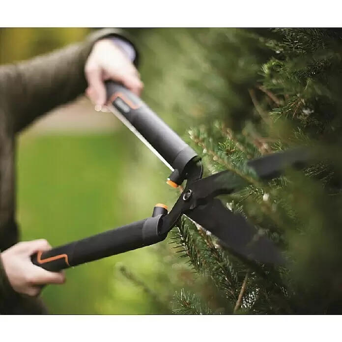 Fiskars SingleStep Hand-Heckenschere HS22 - Länge: 58 cm, Schwarz, Orange - Person schneidet eine Hecke mit schwarzen und orangefarbenen Heckenscheren.