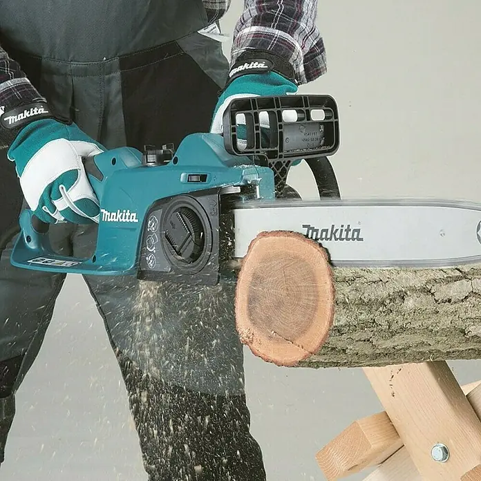 Makita Elektro-Kettensäge UC3541A - 1.800 W, Schwertlänge: 35 cm - Nahaufnahme einer Makita Akku-Kettensäge beim Sägen eines Baumstamms. Die Kettensäge ist hellblau und wird von einer Person bedient.