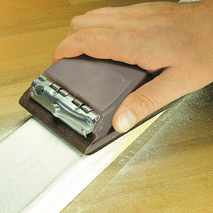 Wolfcraft Lijadora manual - 160 x 85 x 45 mm - Una lijadora manual con papel de lija se utiliza para trabajar una pieza de madera, suavizando su superficie, ideal para tareas de lijado precisas.