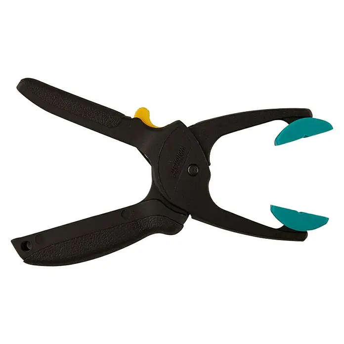 Wolfcraft Pinzas de sujeción Quickfix S - Anchura de sujeción: 30 mm, 2 ud. - Una pinza de resorte negra con mango amarillo y almohadillas azules, aislada sobre un fondo negro.