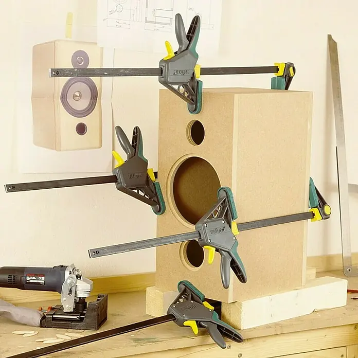 Wolfcraft Tornillo de apriete monomanual EHZ PRO - Anchura de sujeción: 915 mm, Fuerza de tensión: 1.200 N, Apertura máxima: 100 mm - Caja de altavoz asegurada con mordazas de una mano Wolfcraft sobre banco de trabajo. Las mordazas sujetan la caja de forma segura.