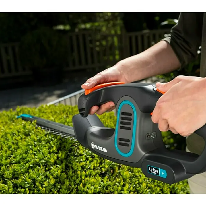 Gardena EasyCut Akku-Heckenschere - 14,4 V, Li-Ionen, 2 Ah, 1 Akku - Eine Gardena Akku-Heckenschere in Aktion, gehalten von einer Person beim Heckenschneiden.