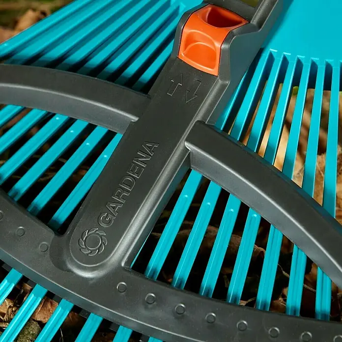 Gardena Combisystem Verstellbesen - Arbeitsbreite: 35 cm - 52 cm, Verstellbare Zinken - Nahaufnahme eines blauen Gardena-Rechens mit grauen Akzenten. Das Werkzeug ist ideal zum Reinigen von Gärten und zum Zusammenkehren von Blättern.