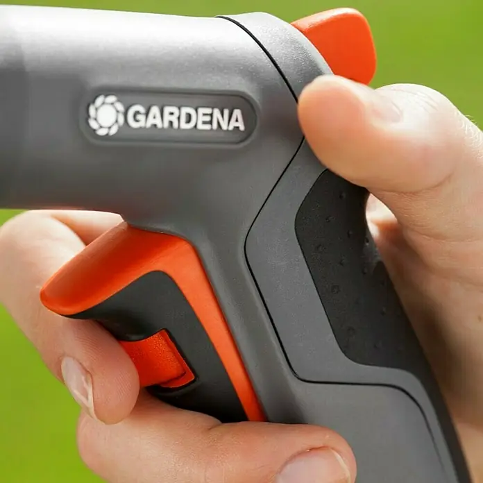 Gardena Comfort Multibrause - Anzahl Sprühformen: 5 Stk., Metall/Kunststoff - Nahaufnahme einer Gardena Gartenspritze in der Hand, die auf einem grünen Hintergrund gehalten wird.