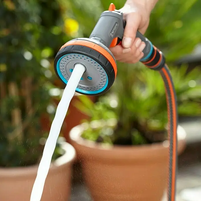 Gardena Comfort Multibrause - Anzahl Sprühformen: 5 Stk., Metall/Kunststoff - Nahaufnahme einer Gardena-Gartenspritze mit Wasserstrahl und Bewässerungsfunktion für Pflanzen.