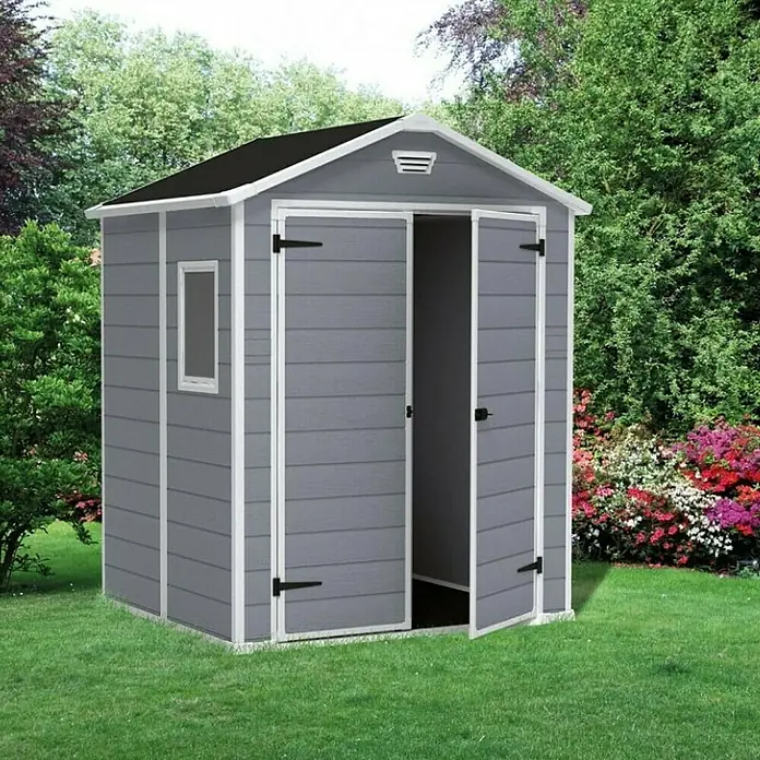 Keter Caseta de jardín Manor 65DD - Medidas ext. (An x Pr): 185 x 152 cm, Antracita/Blanco, Plástico, Área: 2,8 m² - Una caseta de jardín gris con puertas abiertas, rodeada de un jardín verde, ofrece espacio de almacenamiento adicional al aire libre.