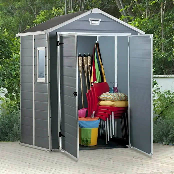 Keter Caseta de jardín Manor 65DD - Medidas ext. (An x Pr): 185 x 152 cm, Antracita/Blanco, Plástico, Área: 2,8 m² - Un cobertizo de jardín gris con puertas abiertas, lleno de herramientas de jardín, se encuentra al aire libre.