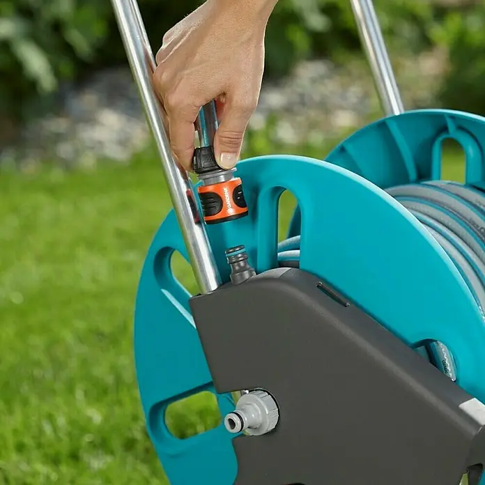 Gardena Schlauchwagen-Set CleverRoll M Easy Set - Kunststoff/Metall, Schlauchlänge: 20 m - Nahaufnahme eines Gardena Schlauchwagens, an den ein Schlauch angeschlossen wird. Praktische Gartenbewässerungslösung mit komfortabler Handhabung.