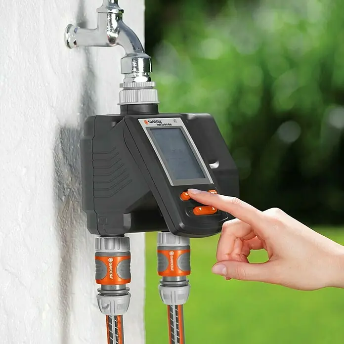Gardena Bewässerungscomputer MultiControl Duo - Bewässerungsdauer: 1 min - 3,59 h, ¾″ - Eine Gardena Bewässerungssteuerung ist an einem Wasserhahn befestigt und wird von einer Hand bedient.