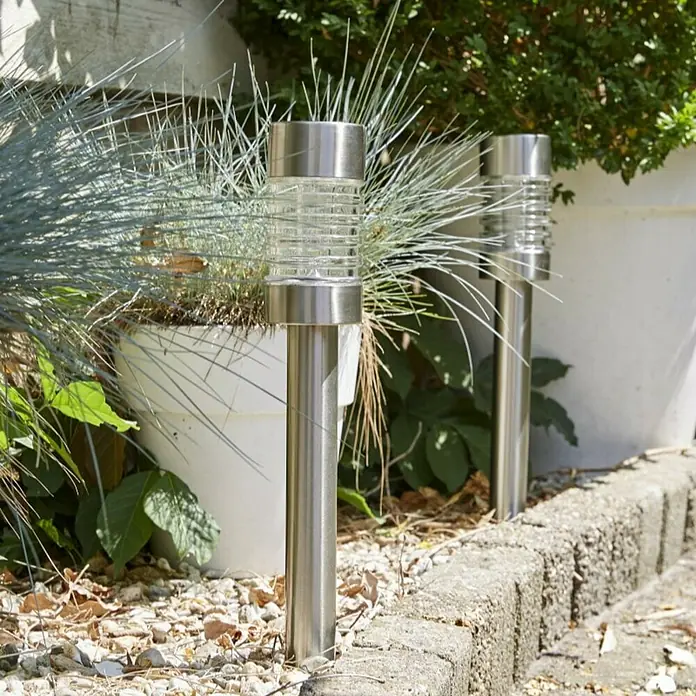 Luxform Solar-Erdspieß Torino - L x B x H: 7,5 x 7,5 x 58 cm, Silber, 8 lm - Nahaufnahme von zwei Solarleuchten aus Edelstahl, die einen Gartenweg beleuchten und eine elegante Note verleihen.