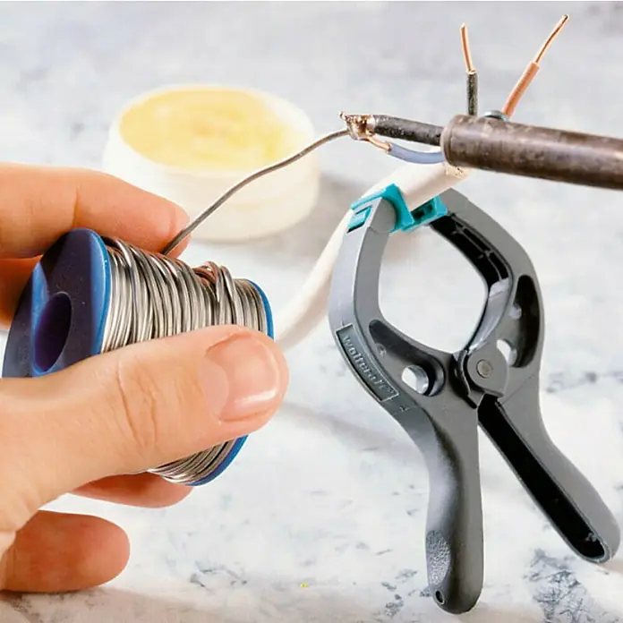 Wolfcraft Pack de abrazaderas Microfix - Anchura de sujeción: 30 mm - Una foto con herramientas para reparación electrónica, incluyendo soldadura, una pinza y un soldador.
