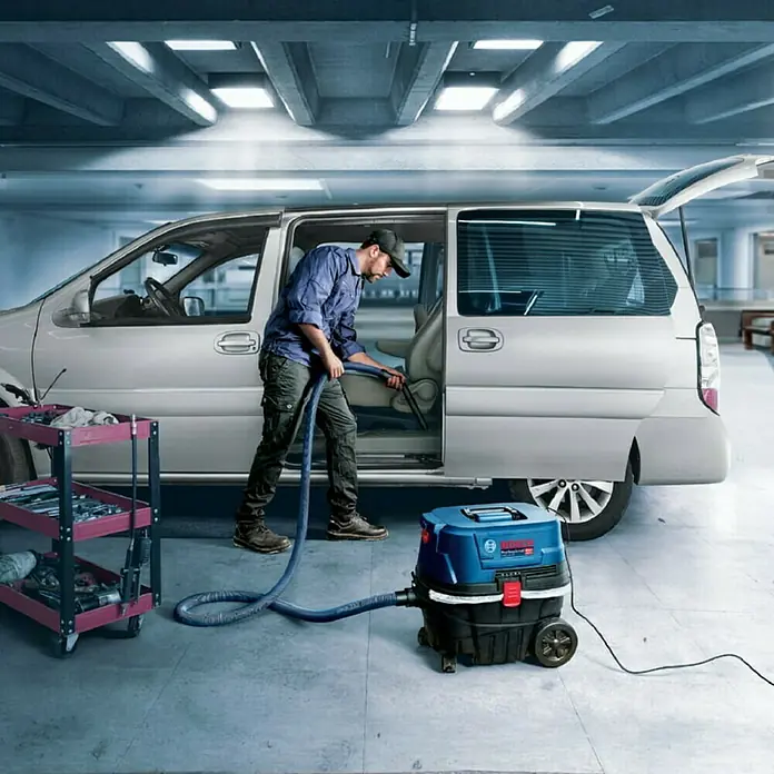 Bosch Professional Elektro-Nass- & Trockensauger GAS 12-25 PL - 1.250 W, Behältervolumen: 25 l, Mit Beutel - Ein Mann reinigt das Innere eines Minivans mit einem Bosch Nass- und Trockensauger in einer Garage.