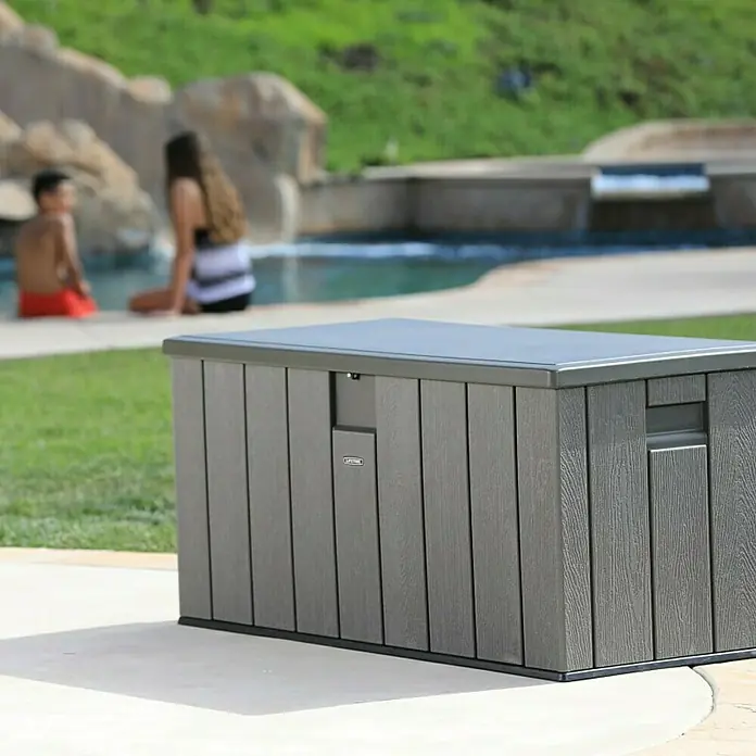 Lifetime Gartenbox - L x B x H: 151 x 72 x 69 cm, Kunststoff, 570 l, Dunkelgrau - Das Bild zeigt eine graue Lifetime-Aufbewahrungsbox im Freien, ideal zur Lagerung von Poolzubehör oder Gartenutensilien. Sie ist wetterfest und langlebig.