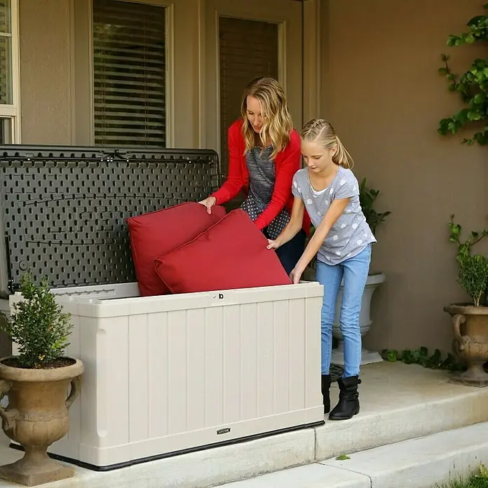 Lifetime Gartenbox Harmony - 128 x 64 x 67 cm, Lichtgrau, Kunststoff - Mutter und Tochter verstauen rote Kissen in einer Lifetime Aufbewahrungsbox im Freien.