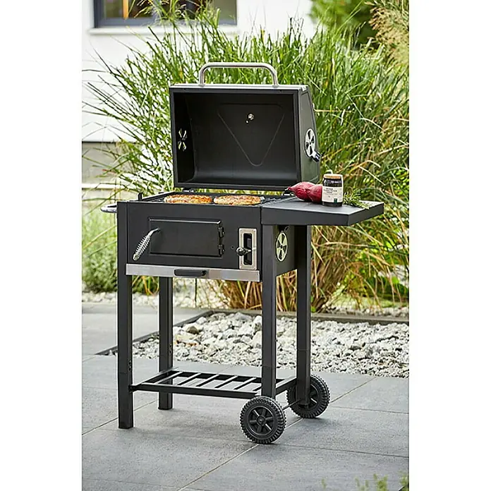 Grillstar Barbacoa de carbón Boston - Superficie de la parrilla (An x Pr): 45 x 32 cm, Negro - Una barbacoa de carbón negra con tapa abierta, comida en la parrilla y accesorios en la estantería, ideal para barbacoas al aire libre.