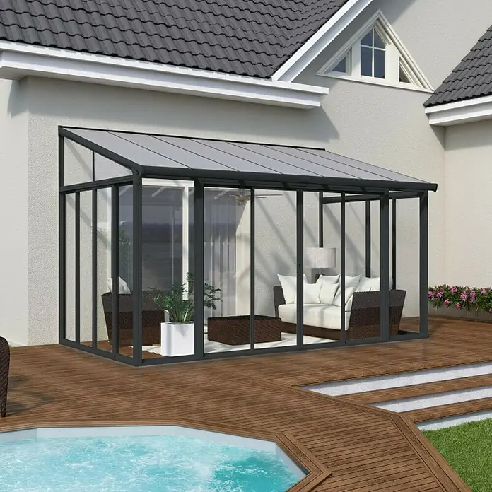Palram – Canopia Porche acristalado San Remo - An x Pr x Al: 4,25 x 3 x 3,1 m, Gris antracita - Imagen de un moderno invernadero de cristal con marco oscuro, conectado perfectamente a una casa, creando un elegante espacio habitable al aire libre.
