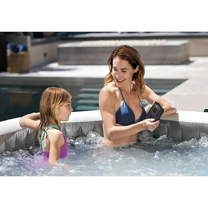 Intex Pure Spa Hidromasaje móvil Greywood Deluxe - Ø x Al: 196 x 71 cm, Gris/Blanco, 795 l - Mujer y niño en una bañera de hidromasaje con controles digitales.