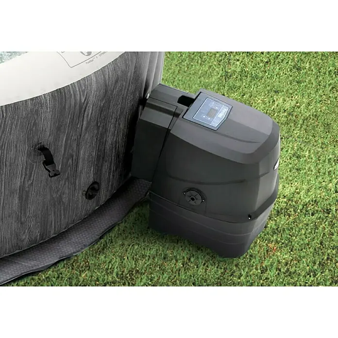 Intex Pure Spa Hidromasaje móvil Greywood Deluxe - Ø x Al: 196 x 71 cm, Gris/Blanco, 795 l - Primer plano de una bomba Lay-Z-Spa negra sobre hierba verde, destacando el diseño detallado del producto.