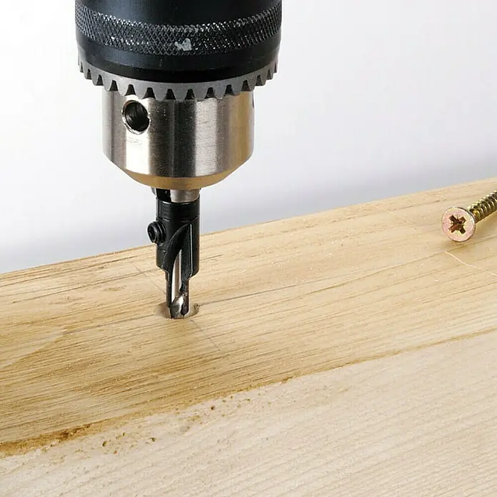 Wolfcraft Broca para madera - 2 ud., Diámetro de la broca: 16 mm - Taladro con broca avellanadora perforando una tabla de madera, con un tornillo al lado. Ideal para proyectos de carpintería.