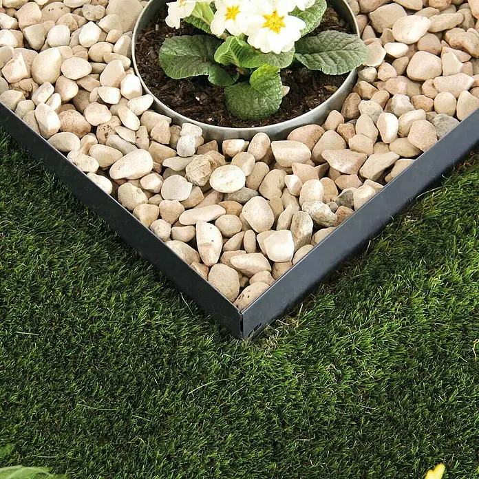 Bellissa Rasenkante Serra - 103 x 0,1 x 12 cm, Silber, Metall - Nahaufnahme einer Rasenkante aus Metall, die einen Kiesbereich mit einer Blumenpflanze vom Rasen trennt und ein gepflegtes Gartenbild erzeugt.