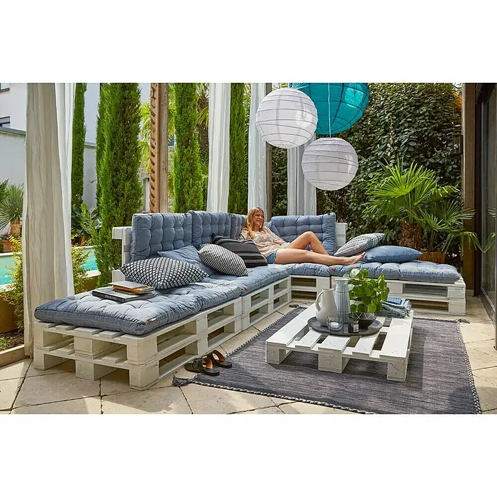 Deko-Palette - 120 x 80 x 14 cm, Weiß - Eine einladende Loungeecke im Freien mit Palettenmöbeln und blauen Polstern, ideal zum Entspannen im Garten oder auf der Terrasse.