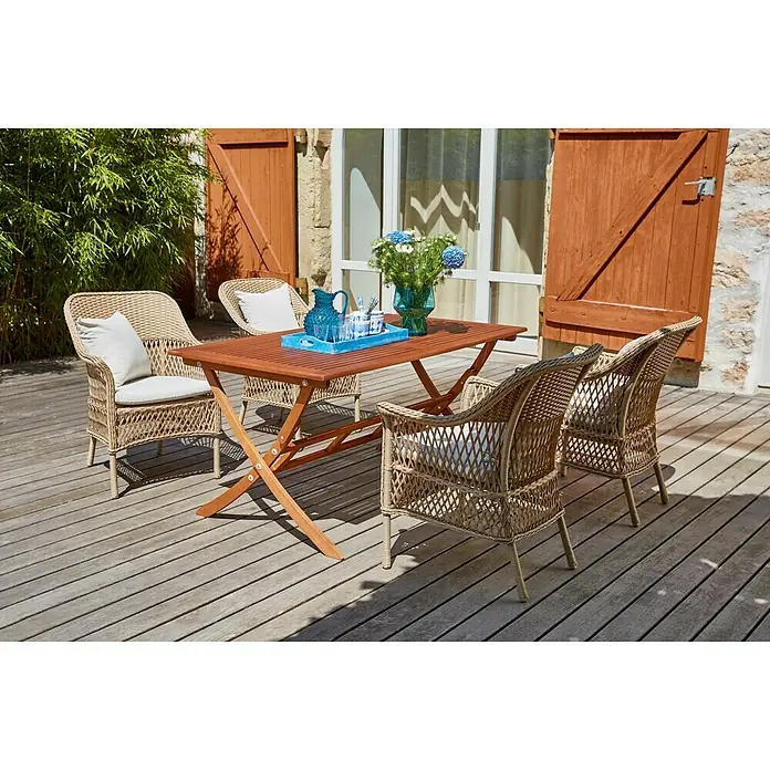 Sunfun Sillón de jardín Sophie - An x Pr x Al: 64 x 65,5 x 87,5 cm, Beige, Caramelo, Apilable - Un elegante conjunto de comedor al aire libre con mesa de madera y cuatro sillas de mimbre con cojines claros en un patio de madera.