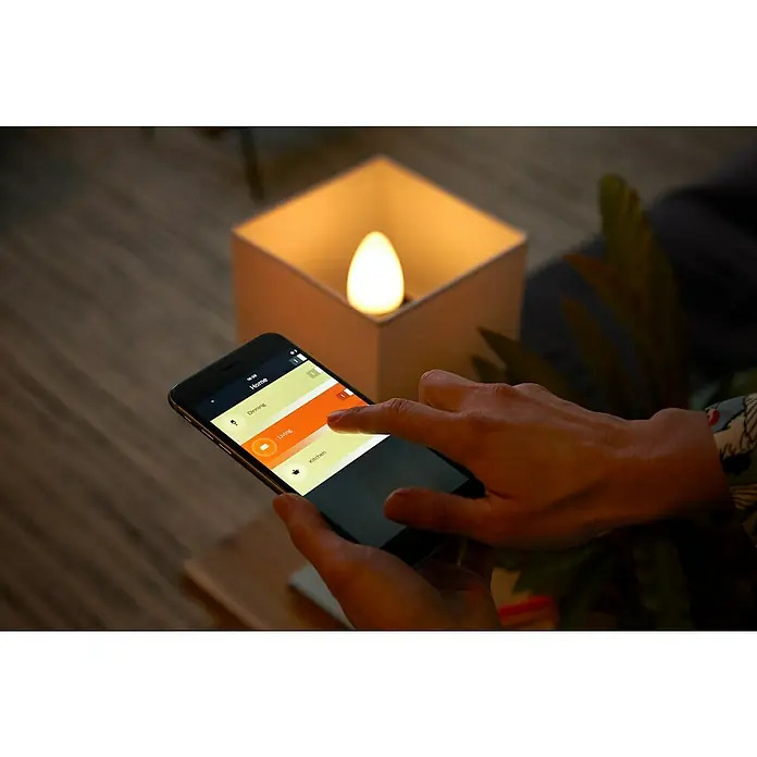 Philips Hue Smart-LED-Lampen Set - E14, Dimmbar, RGBW, 470 lm, 5,3 W - Smartphone steuert eine intelligente Glühbirne in einem weißen Gehäuse. Innovative Lichtsteuerung für Ihr Zuhause per App.
