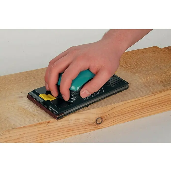 Wolfcraft Lijadora manual - Plástico - Primer plano de un bloque de lijado manual en uso sobre un trozo de madera.