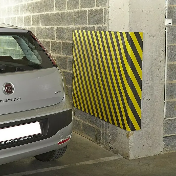Mottez Schaumstoffmatte - L x B: 150 x 100 cm, Stärke: 1 cm - Das Bild zeigt einen gelb-schwarz gestreiften Eckenschutz, der an einer Wand in einer Garage angebracht ist, um Autos vor Beschädigungen zu schützen.