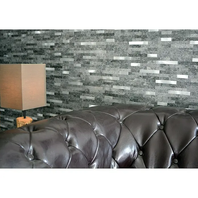 Selbstklebemosaik SAM 4IL22BS - 30 x 29 cm, Schwarz/Silber, Matt - Nahaufnahme eines braunen Ledersofas mit Knöpfen, hervorgehoben durch eine Lampe und eine Wand mit Silberakzenten.