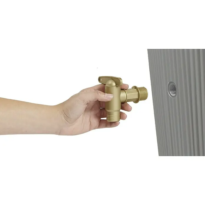 4rain Regenspeicher Vaso Decor 2in1 - 220 l, Zinkgrau - Eine Hand hält einen goldenen Wasserhahn, der bereit ist, an einem grauen Tank befestigt zu werden. Der Hahn ist mit Gewinde versehen.