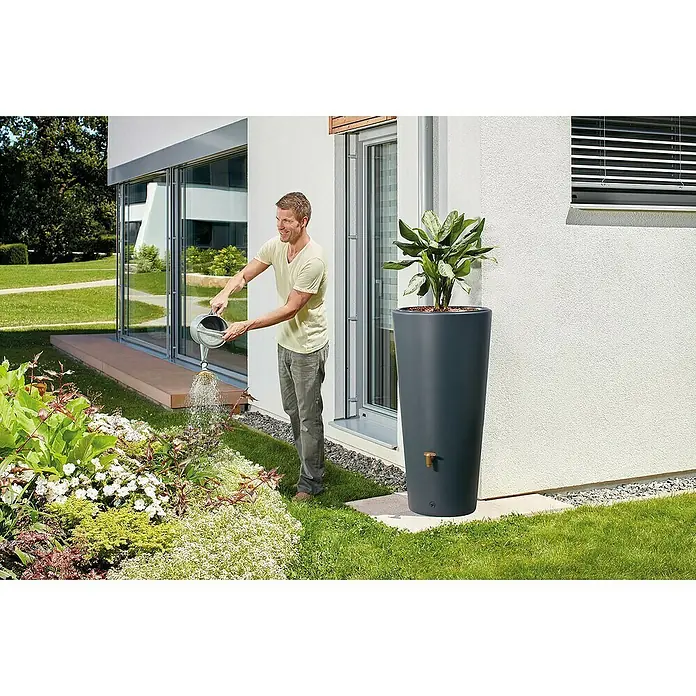 4rain Regenspeicher Vaso 2in1 - 220 l, Darkgranite - Mann gießt Blumen mit einer Gießkanne neben einem grauen Pflanzgefäß mit integriertem Wasserspeicher, der für die Gartenbewässerung geeignet ist.