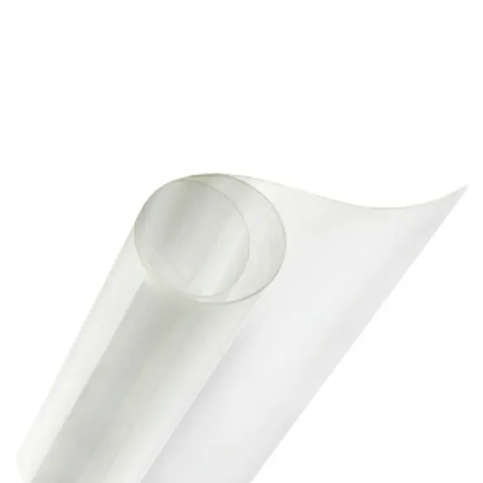 Film protector PET - 1 x 1 m - Primer plano de un rollo de film plástico transparente, curvándose sobre un fondo negro, permitiendo que la luz lo atraviese.