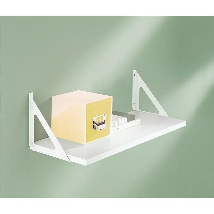 Dolle Soporte de pared para estantes Triangolo - L x An: 60 x 25 cm, Carga soportada: 50 kg, Blanco, Acero - Una estantería de pared blanca con un diseño minimalista, que muestra una caja amarilla y libros colocados encima. Almacenamiento elegante.