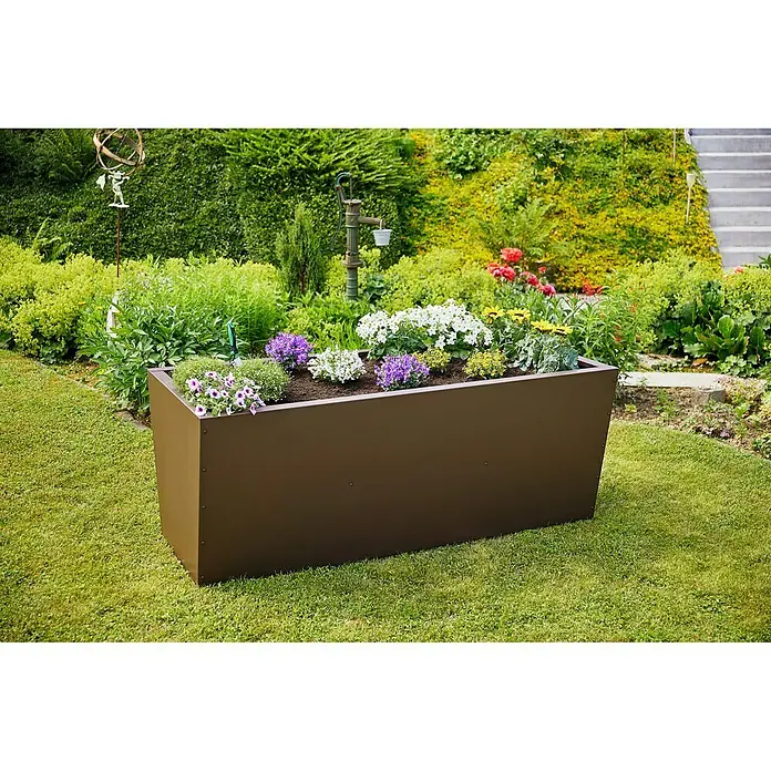 Gutta Hochbeet Valenta 200 - 200 x 90 x 80 cm, Aluminium, Rost Matt - Das Bild zeigt einen rechteckigen, braunen Pflanzkasten im Garten, bepflanzt mit verschiedenen bunten Blumen. Der Kasten ist aus Metall und steht auf Rasen.