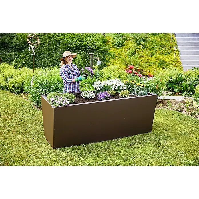 Gutta Hochbeet Valenta 200 - 200 x 90 x 80 cm, Aluminium, Rost Matt - Frau gärtnert in einem braunen, erhöhten Pflanzgefäß voller Blumen.