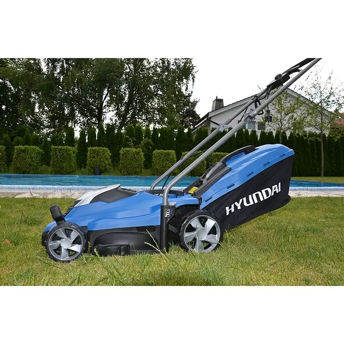 Hyundai Elektro-Rasenmäher LM3301E - 1.300 W, Schnittbreite: 33 cm - Blauer Hyundai Rasenmäher auf Rasen mit Fangkorb. Das Gerät ist hochwertig und benutzerfreundlich für eine perfekte Rasenpflege.