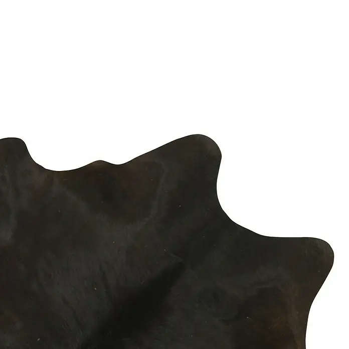 Esbeco Kuhfell - Exotisch Dunkel, 100 % Echtfell - Detailaufnahme eines schwarzen Kuhfells mit einzigartiger Form und Textur, ideal für stilvolle Wohnaccessoires.