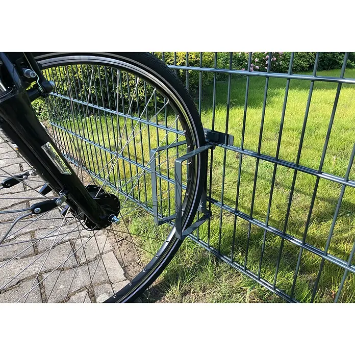 WMT Eindrehhalterung als Fahrradständer - Anthrazit - Nahaufnahme eines Fahrradständers am Zaun, der das Fahrrad sicher hält. Praktische Lösung zur Fahrradaufbewahrung im Freien.