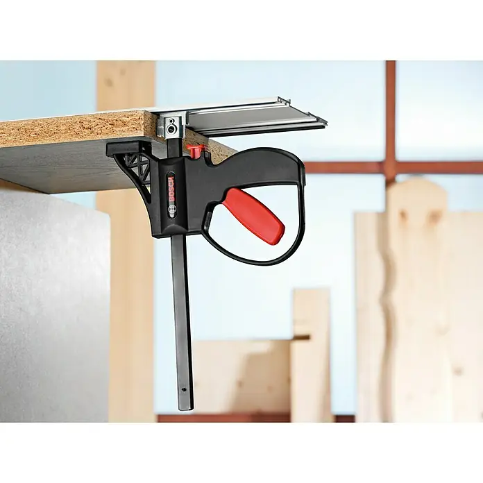 Bosch Professional Einhandzwinge FSN KZW - L x H: 295 x 205 mm, 2 Stk. - Eine schwarze Bosch Einhandzwinge hält ein Holzbrett fest, ideal für präzise Werkstattarbeiten.